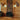 Two black MUS104 farmhouse lantern wall sconces lit on a knotty pine cabin wall